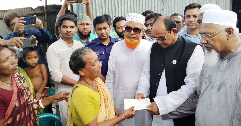বীরেন চন্দ্র রায়ের বাড়িতে নিহত চারজনের জন্য চেক দিচ্ছেন ধর্ম প্রতিমন্ত্রী ফরিদুল হক খান